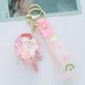 Close-up of pink acrylic oil-filled lollipop keychain with glitter and a cute pastel strap - Pink