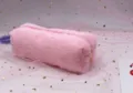 Close-up detail of a soft pink plush octagonal pencil case with a cute zipper closure. - Light Pink