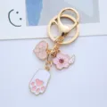 Macro detail of a cute pink cat paw and sakura cherry blossom charm on a gold keychain - Single Piece / Peach Rabbit Paw
