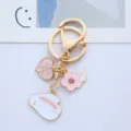 Detailed macro view of a cute pink rabbit and floral gold-tone charm keychain for bags - Single Piece / Peach Rabbit