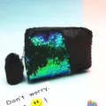 Vista detallada de un neceser de lentejuelas reversibles con un pompón negro suave. - Verde y Negro Mate