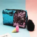 Vista detallada de un estuche de lentejuelas reversibles con pompón negro suave. - Azul + Rosa Claro
