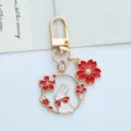 Cute gold-tone enamel keychain featuring a white rabbit with red cherry blossom charms. - Red Bowtie Rabbit - Gate Clasp