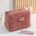 Neceser de terciopelo rosa con rayas acolchadas que muestra textura y detalle. - L / Rosa empolvado