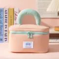 Close-up front view of peach pink and mint green travel makeup bag with soft handle - Pink