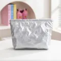 Primer plano detallado de un neceser plateado acolchado con elegantes patrones de lazos. - Estilo Lazo / Tamaño Estándar / Plateado