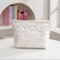Detalle de neceser blanco acolchado con patrón de corazones y elegante acabado perlado - Estilo Corazón / S / Beige