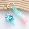 Detail view of a cute lollipop-shaped quicksand keychain with a colorful strap - Oil-Filled Lollipop / Blue