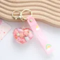 Close-up of a cute pink heart-shaped quicksand keychain with tiny shells and glitter. - Pink