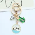 Detailed view of the cute panda and bamboo charms on a gold-toned creative keychain. - Bathing Panda