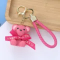 Detail of pink resin teddy bear keychain with woven texture and gold clasp - Rose Red