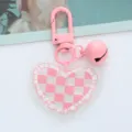 Detailed view of a pink checkered acrylic heart keychain with a matching bell accessory - Pink Plaid Heart