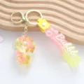Macro view of a cute liquid quicksand astronaut keychain with pink bubble strap. - Yellow Liquid Astronaut Style