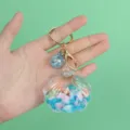 Detailed view of clear shell keychain with blue oil-filled quicksand and shells. - Shell Decoration / Blue Shell