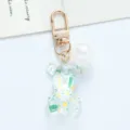 Close-up detail of a transparent acrylic bear keychain with colorful glitter spots. - White