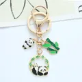 Detailed view of a cute enamel panda keychain with bamboo and round panda charms - Leaning Panda
