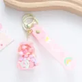 Detailed view of a cute pink unicorn oil-filled floating bottle keychain with a rainbow strap - Pink Liquid Unicorn Style