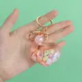 Close-up detail of the heart-shaped charm with internal seashells and glitter ball - Heart Pink