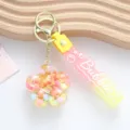 Detail view of pink acrylic floral liquid quicksand keychain with gradient Bubble strap - Liquid Plum Blossom / Yellow