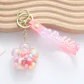 Detail of flower-shaped liquid keychain with colorful quicksand and pink wrist strap - Liquid Plum Blossom / Pink