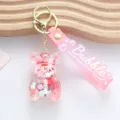 Close-up of a pink bear shaker keychain with colorful beads and white snow particles - Jelly Bean Bear Style / Pink