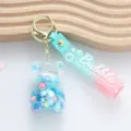 Close-up of blue shaker bear keychain with "Bubble" wrist strap and liquid glitter - Jelly Bean Bear Style / Blue