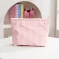 Vista detallada de un neceser rosa acolchado con motivos de lazos grabados en relieve - Estilo Lazo / Tamaño Estándar / Rosa