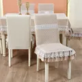 Detailed view of quilted chair covers with elegant white lace trim and ruffles. - Note: 130x180cm Rectangular Tablecloth / Romantic Encounter - Beige