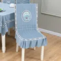 Vue detaillee de la housse de chaise bleu clair brodee de fleurs et nappe assortie. - Housse de Chaise Monobloc / Gris