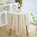 Vue détaillée de la nappe en dentelle crème avec broderie florale sur une petite table - 145*50CM / Queue de phénix beige