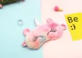 A macro detail of a colorful gradient unicorn plush sleep mask with soft texture - Pink