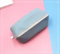 Gros plan détaillé d'une trousse en cuir PU bleu poussiéreux avec fermeture éclair blanche - Bleu