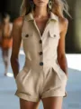 Close-up detail of the beige sleeveless button-down utility romper, featuring lapel and pockets. - Apricot