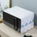Detailed view of white lace microwave dust cover featuring blue flower embroidery - Flower Basket