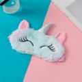 Soft plush unicorn sleep mask featuring a silver glitter horn and closed eyelashes detail - Light Blue