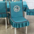 Close-up of the teal quilted chair cover featuring elegant swan embroidery and ruffles - Chair Cover / Integrated Swan Blue