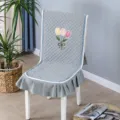 Detailed view of grey quilted chair cover with tulip embroidery and ruffled skirt - One Size / Tulip One-Piece Grey