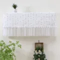Vista dettagliata di un copricondizionatore in pizzo bianco con gocce e frange a pompon - 1-1,5 CV (Lunghezza entro 86 cm) / Bianco frutta moda - Non serve togliere all'accensione