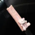 Close-up of pink fuzzy car seat belt cover featuring a plush bear and rabbit embroidery detail. - Pink Bear