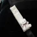 Close-up detail of white fluffy bear car seat belt shoulder pad featuring cute plush bear doll - White Bear