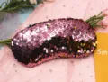 Close-up detail of a pink reversible mermaid sequin sleep eye mask for travel and relaxation - Pink and Gold