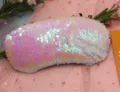 Close-up of reversible iridescent mermaid sequins on double-sided travel eye mask - Pink White