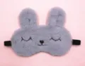 Macro view of a cute grey plush bunny sleep mask with embroidered eyes on pink background - Squinty Eye Rabbit / Gray