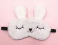 Close-up detail of white plush rabbit sleep mask featuring a cute embroidered face - Squinty Eye Rabbit / White