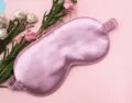 Close-up detail of a soft pink silk sleep mask featuring smooth satin texture and elastic strap - Deep Pink