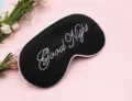 Detailaufnahme der schwarzen Schlafmaske mit weißem Good Night Stickerei und Blumen - Schwarz (Weiße Krempe)