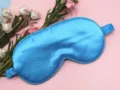 Detail of smooth blue satin sleep mask with soft elastic head strap and silk-like texture. - Sky Blue