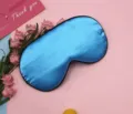 Detailed close-up view of the smooth blue satin sleep mask featuring premium black piping - Sky Blue