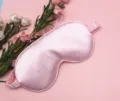 Detailed macro view of smooth pink silk sleep mask showing high-quality satin texture - Light Pink