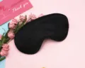 Detailed view of a luxurious black silk satin sleep mask with complete blackout design. - Black